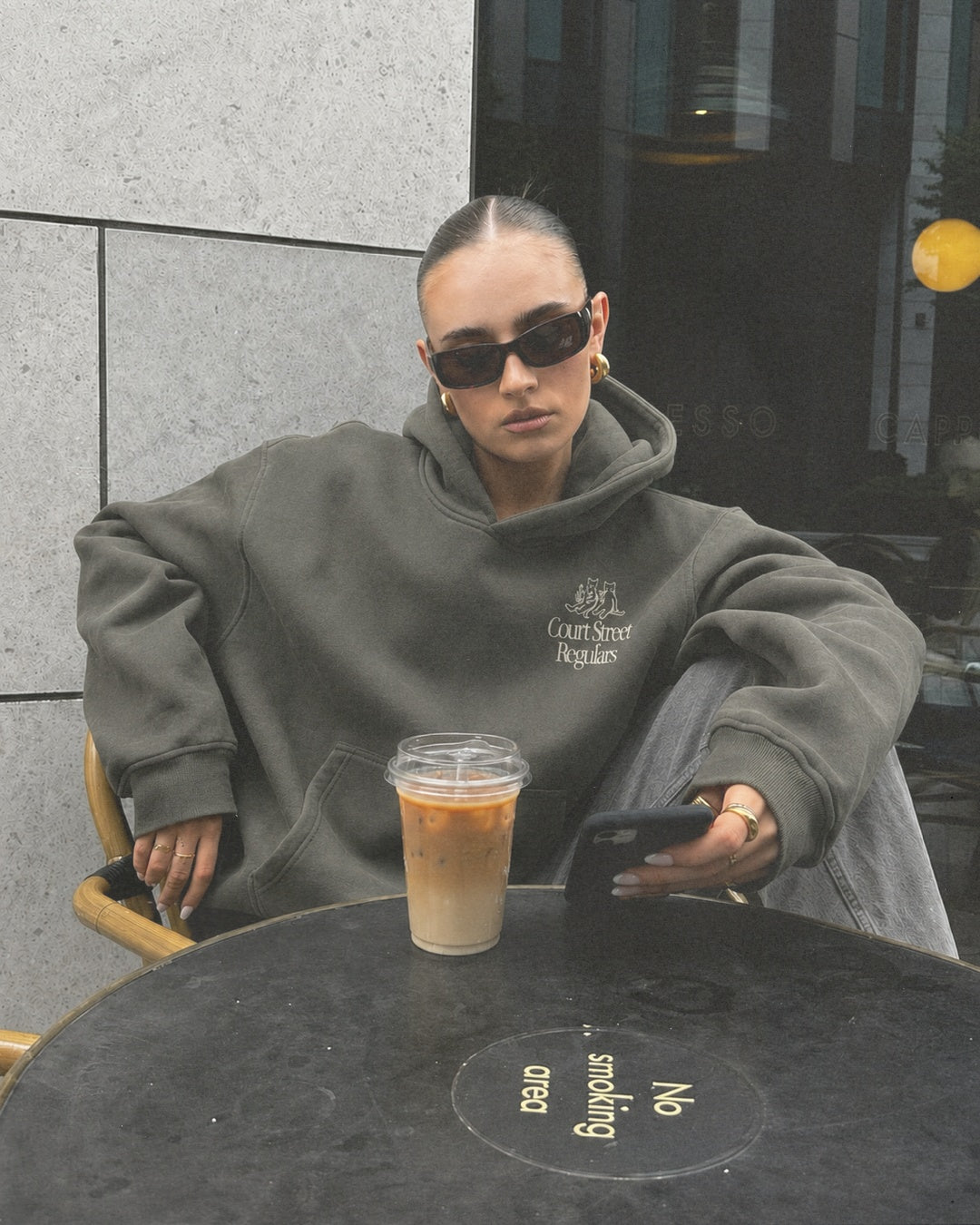 Court Street Regulars Charcoal Hoodie — worn, cafe