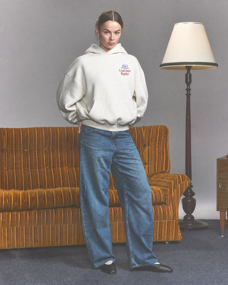 Court Street Regulars White Hoodie — model couch shot